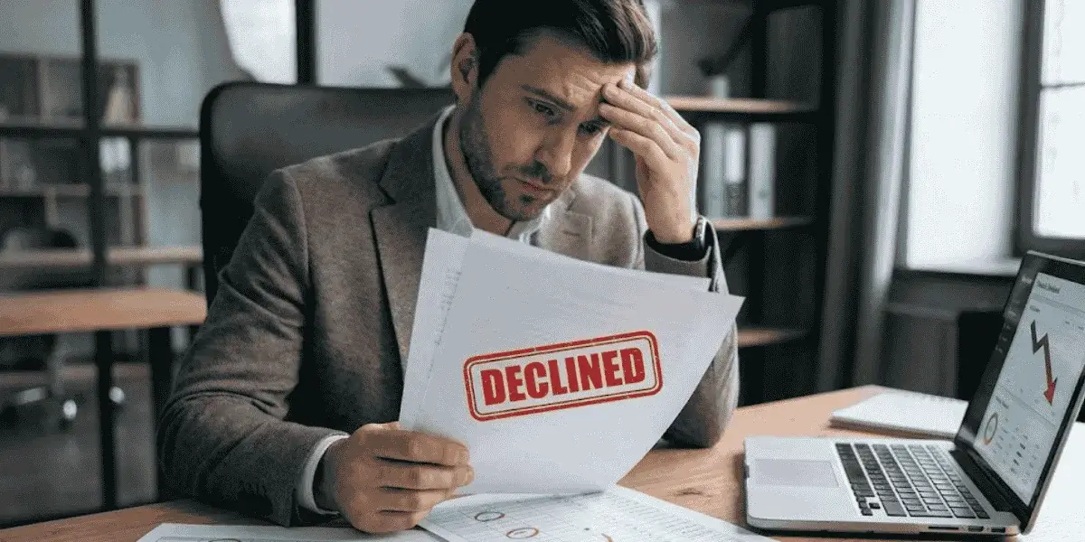 man reviewing declined paperwork showing challenges in getting business loans for bad credit