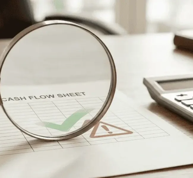 small business loan interest rates review cash flow sheet with magnifying glass